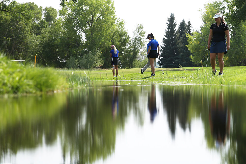 Riley Tomich, right, helps look for another golfers ball